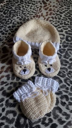 two pairs of baby shoes and a knitted bear hat