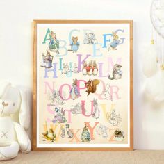 an animal alphabet is displayed in front of a teddy bear and stuffed animals on a shelf