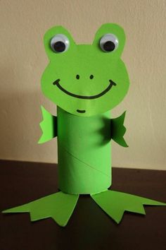 a green paper frog sitting on top of a table