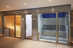 an indoor sauna is lit up with candles and lights on the side of it