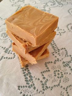 three pieces of peanut butter fudge sitting on top of a doily covered table