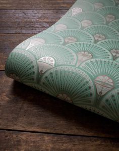 a close up of a cushion on a wooden floor with an umbrella pattern in the background