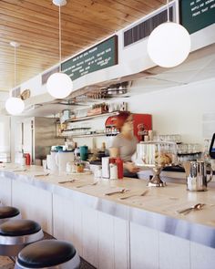 an empty restaurant bar with stools and counters