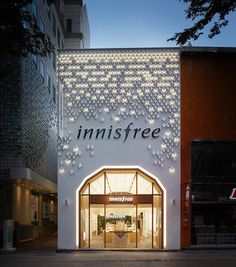 the entrance to an innisfree store lit up at night with lights on it