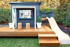 an outdoor play area with slide, bench and potted plants on the decking