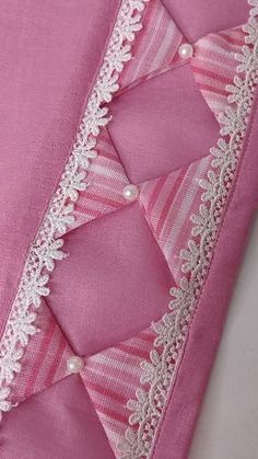 pink and white fabric with lace trims on the bottom half of it, as well as an applique