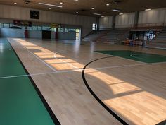 an indoor basketball court with hard wood floors