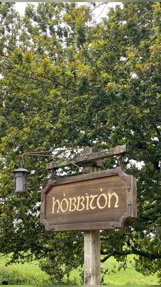 a wooden sign with the word hobbisto on it in front of some trees