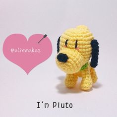 a small crocheted dog with a pink heart in the background that says, i'm pluto