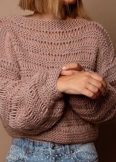 a woman with blonde hair wearing a pink sweater