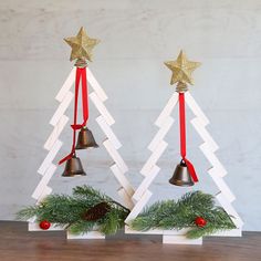 two wooden christmas trees with bells on them