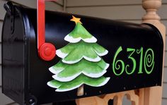 a mailbox with a christmas tree painted on it's front and the number 519