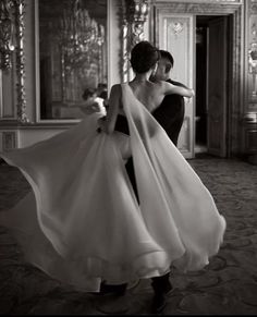 a woman in a black and white photo holding a dress