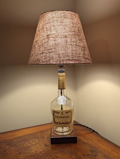 a lamp that is sitting on top of a wooden table next to a glass bottle