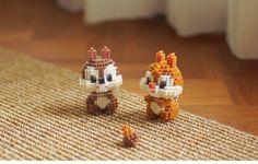 two small knitted animals sitting on top of a rug