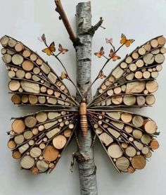 a butterfly made out of wood sitting on top of a tree