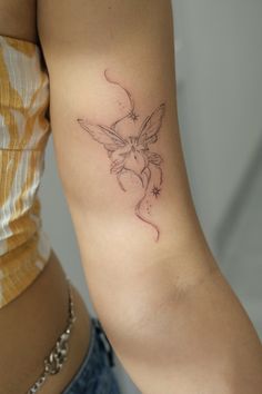 a woman's arm with a small tattoo design on the back of her left arm