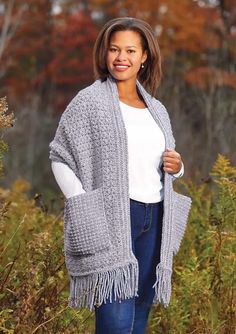 a woman wearing a gray knitted shawl