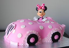 a minnie mouse cake on top of a pink car with white polka dots and black wheels