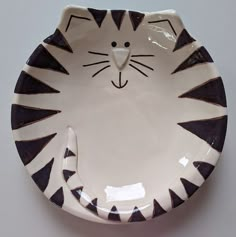 a white and black plate with a cat face on it