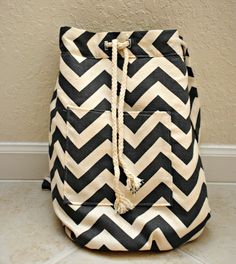 a black and white chevroned bag sitting on the floor next to a wall