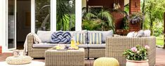 an outdoor patio with wicker furniture and potted plants