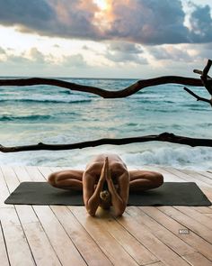 a woman is doing yoga on the beach