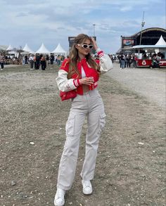 Cream cargo pants, festival outfit, varsity jacket, white sunglasses Cargo Pants Festival Outfit, Style White Cargo Pants, Cargo Pants Festival, Pants Festival Outfit, White Cargo Pants Outfit, White Denim Jacket Outfit, Cream Cargo Pants Outfit, Cream Cargo Pants, Ootd Korean Style