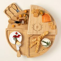 a wooden platter with cheeses, crackers and other food items on it