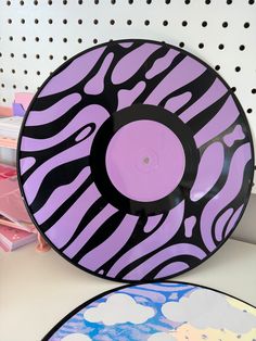 two plates sitting on top of a table covered in purple and black zebra print designs