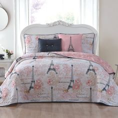 a bed with a pink and white comforter in front of a window