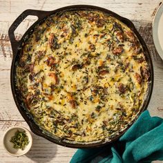 a casserole with cheese and spinach in a pan on a wooden table