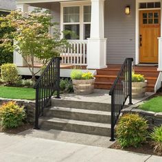 a house with steps leading up to the front door and landscaping on either side of it