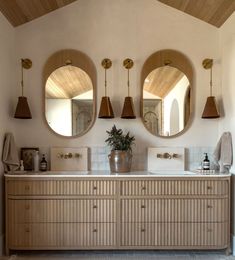 a bathroom with two sinks and three mirrors