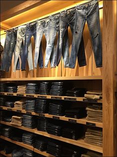 several pairs of jeans are hanging on the wall next to each other in a store