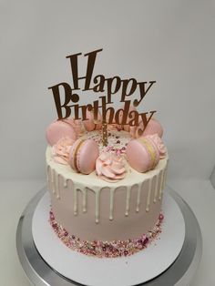 a birthday cake decorated with pink frosting and sprinkles on a silver platter