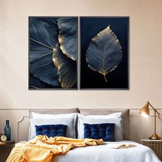 two large leaf prints on the wall above a bed