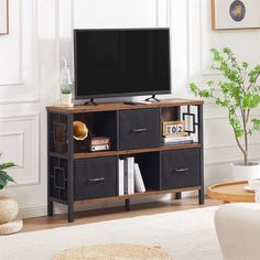 a living room with a large tv on top of a wooden entertainment center next to a white rug