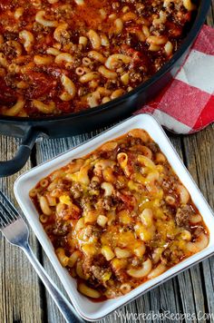 a casserole dish with meat and cheese in it next to a red checkered napkin