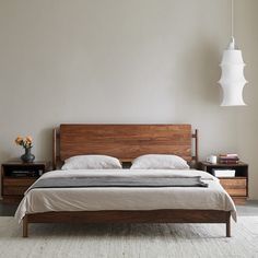 a bedroom with a bed, nightstands and lamp hanging from the ceiling above it