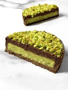 two pieces of chocolate and pistachio covered dessert