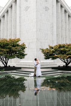 a bride and groom standing in front of the lincoln memorial with their arms around each other