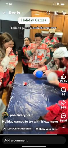 a group of people standing around a table with some balls on it and one person holding a blue ball