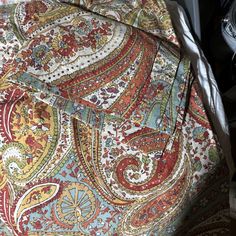 a close up of a bed with a paisley pattern on it