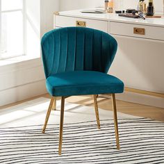 a blue chair sitting on top of a rug in front of a white countertop