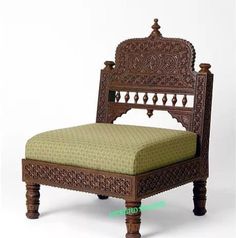 an ornate wooden chair with a green upholstered seat