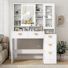 a white desk with two drawers and a mirror on it in a room next to a couch