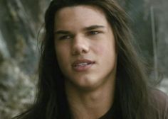 the young man with long hair is looking at the camera