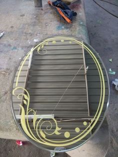 a round table with an artistic design painted on the top and yellow paint around it