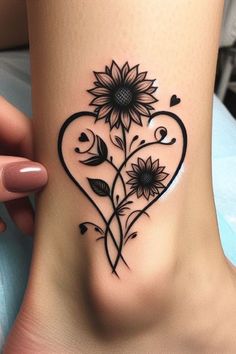 a heart shaped tattoo with sunflowers and hearts on the side of the foot